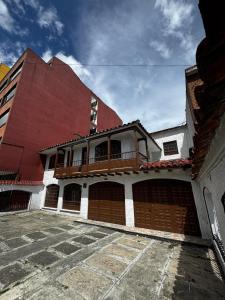 Casa Cocora في بوغوتا: مبنى احمر وبيض مع شرفه عليه
