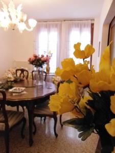 una sala da pranzo con tavolo e fiori gialli di B&B Exclusive a Venezia