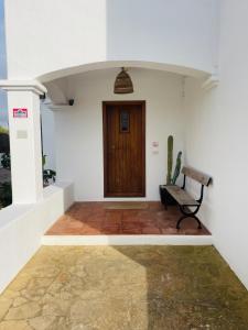 a hallway with a bench and a wooden door at Authentic Villa with amazing pool in Santa Gertrudis de Fruitera +68 photos