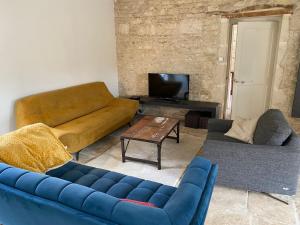 a living room with a blue couch and a table at Grande maison familiale avec piscine, 14 à 17 pers in Luçon