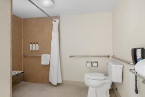 une salle de bain avec des toilettes blanches et une douche dans l'établissement Fairfield Inn & Suites Anaheim North Buena Park, à Buena Park 18 autres photos