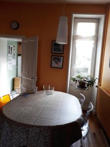 a dining room with a white table and two windows at Quartier De La Madeleine in Sorges