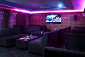a room with couches and a tv on a brick wall at Hotel New Jasmine in Cuttack