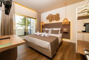 ザンブジェイラ・ド・マールにあるAlojamento Costa Alentejanaのベッドと机とテレビのある寝室