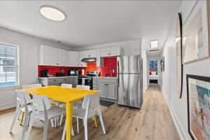 a kitchen with a yellow table and white cabinets at Pet Friendly Condo across from the beach in Myrtle Beach