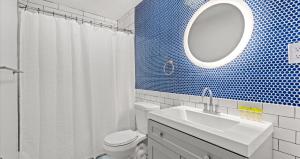 a bathroom with a sink and a toilet and a mirror at Cabana Beach 4 Bright 2BR Condo Steps from the Sand in Myrtle Beach