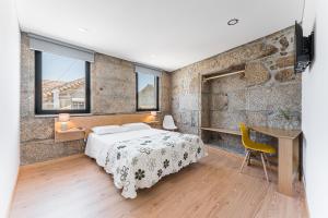 a bedroom with a bed and a desk and some windows at Sevenfarm Turismo Rural in Mangualde +56 photos