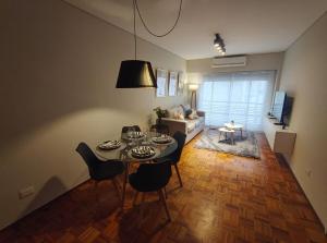 a living room with a table and chairs and a couch at Cálido y luminoso semipiso en Parque Chacabuco in Buenos Aires