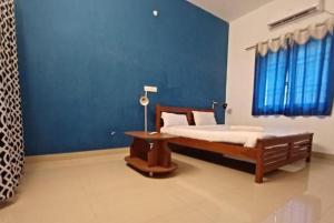 a bedroom with a bed and a blue wall at Green Tree Inn 