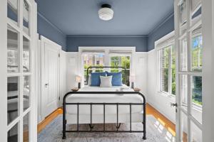 a bedroom with a bed with blue walls and windows at The Adaline - Entire Complex In Hyde Park in Tampa