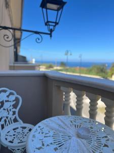 a table and chairs on a balcony with a view of the ocean at La Romantique Rooms and Apartments TROPEA in Parghelia