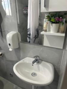 a bathroom with a white sink and a mirror at HH Lakes Tuzla - city center, free parking! in Tuzla +19 photos
