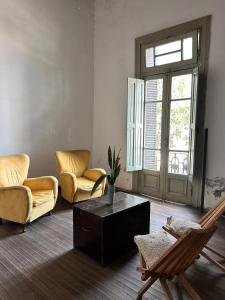 グアレグアイチュにあるcostanera houseの椅子2脚とテーブルのあるリビングルーム