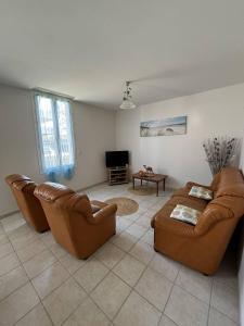 a living room with two couches and a tv at Le bourg 2 in Mimizan