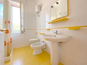 a white bathroom with a toilet and a sink at Casa Vacanze Angelo in Palinuro +43 photos