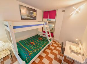 Cette petite chambre dispose de lits superposés et d'une échelle. dans l'établissement IDEAL Plein Centre - 65m2- Piscine et Garage, à Perpignan