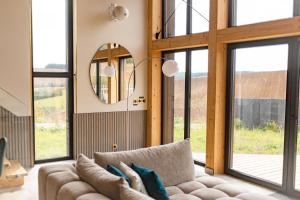 a living room with a couch and large windows at Ostara Ecolodge in Saint-Mards-en-Othe +80 photos