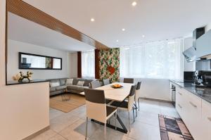 维勒班"La Casa verde" chic et cosy en hypercentre avec climatisation的配有桌椅的厨房和客厅