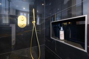 维勒班"La Casa verde" chic et cosy en hypercentre avec climatisation的一间带黄色软管淋浴的浴室