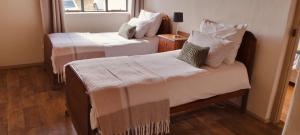a room with two beds and a window at Scheepers Rust Guest Farmhouse in Montagu