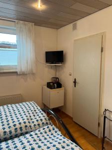 a bedroom with a bed and a flat screen tv at Zimmer 1 inkl eigenem Bad und Parkplatz in Waldböckelheim
