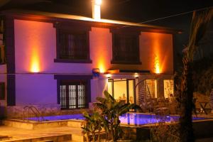 a house with purple lights on the side of it at lamoza in Narlıdere