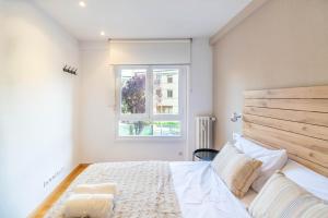 a bedroom with a large bed and a window at Acogedor apartamento ideal para familias in Barañáin