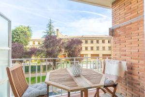 a table and chairs on a balcony with a view of a building at Acogedor apartamento ideal para familias in Barañáin