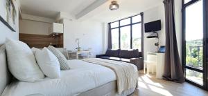 a bedroom with a white bed and a large window at L'Adriana 202 - Clim & wifi - Proximité mer in Carry-le-Rouet