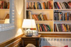 a lamp on a table in a room with books at Magnifica casa rural para familias en Navarra in Unzué +42 photos