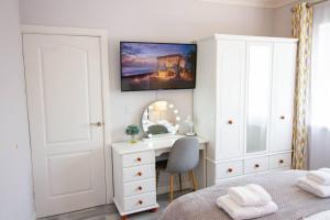 a bedroom with a desk and a bed with a mirror at Bungalow Step Free Access - Close To The Beach in Port Talbot +19 photos