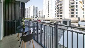 a balcony with a table and chairs and buildings at 1BR Cozy Yas Island with 10 Min to Grand Prix in Abu Dhabi