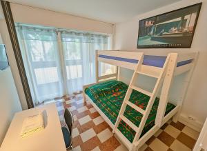 un lit superposé dans une petite pièce avec un bureau et une échelle dans l'établissement IDEAL Plein Centre - 65m2- Piscine et Garage, à Perpignan