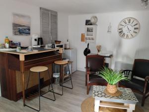 a living room with a desk and chairs and a clock at Launay in Chènehutte-les-Tuffeaux