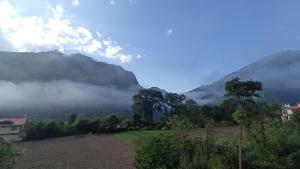 a view of a mountain range with clouds in the sky at Yellow Valley Homestay in Solan +14 photos