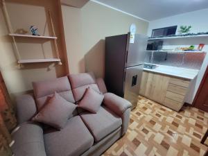 a living room with a couch and a kitchen at Departamento, LUJO HOGAR cerca a PLAZA NORTE - UNI AEROPUERTO in Lima +70 photos