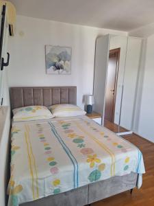 a bedroom with a large bed with a flower blanket at Apartments Romana in Slatine +72 photos