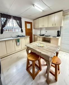 una cucina con un tavolo di legno e due sedie di The Lemon Tree Self Catering Cottage a Bloemfontein