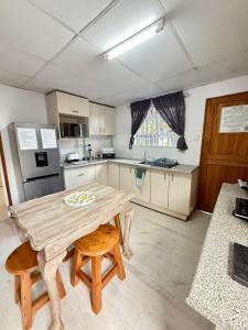 una cucina con un tavolo di legno e due sedie di The Lemon Tree Self Catering Cottage a Bloemfontein