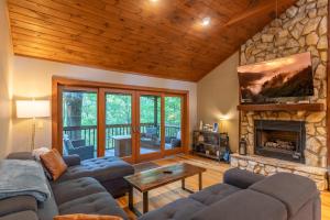 a living room with couches and a stone fireplace at King Bed, Putt-Putt w/ Hot Tub, & Other Games in Banner Elk