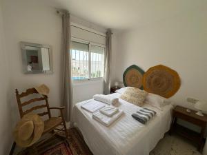 a bedroom with a bed with a chair and a window at Preciosa casa con piscina desbordante y vistas al mar in Roses +44 photos