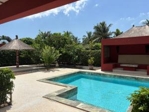une piscine devant une villa dans l'établissement Villa Kër Noflaye - Saly, à Sintiân
