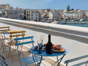 una mesa con una botella de vino y copas en el balcón en CconfortHotels Sea Dream Palace 3, en Trani