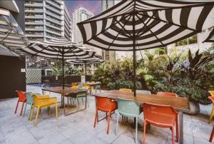 a patio with tables and chairs and umbrellas at Brisbane Central CBD convivence! in Brisbane