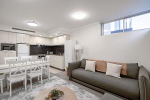 a living room with a couch and a table and a kitchen at Brisbane Central CBD convivence! in Brisbane