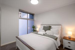 a bedroom with a large white bed with two pillows at Brisbane Central CBD convivence! in Brisbane +22 photos