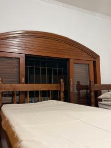 a bedroom with a wooden headboard and a bed at Alpha Hostel in Barueri