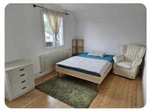 a bedroom with a bed and a chair and a desk at Holzchalet mit Garten in Egnach