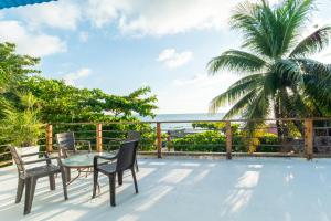 a patio with chairs and a table and a palm tree at Kuruba Beach in Rincón