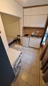 Una pequeña cocina con un fregadero y una mesa. en Jupi, en Pržno